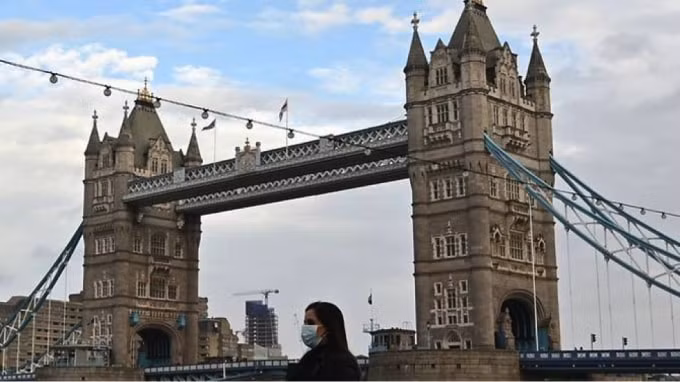 Một người đi bộ đeo khẩu trang vì đại dịch coronavirus đi qua Cầu Tháp ở London vào ngày 1 tháng 11 năm 2020. Ảnh: AFP / Justin Tallis.