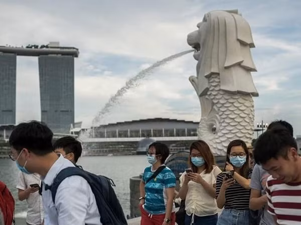 Khách du lịch đi bộ ở công viên Merlion, Singapore. Ảnh: AFP