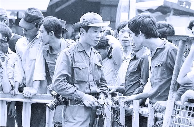 Phóng viên Đinh Quang Thành của Việt Nam Thông tấn xã gặp gỡ, thu thập thông tin từ người dân Sài Gòn trong ngày giải phóng, 30/4/1975. Ảnh: TTXVN
