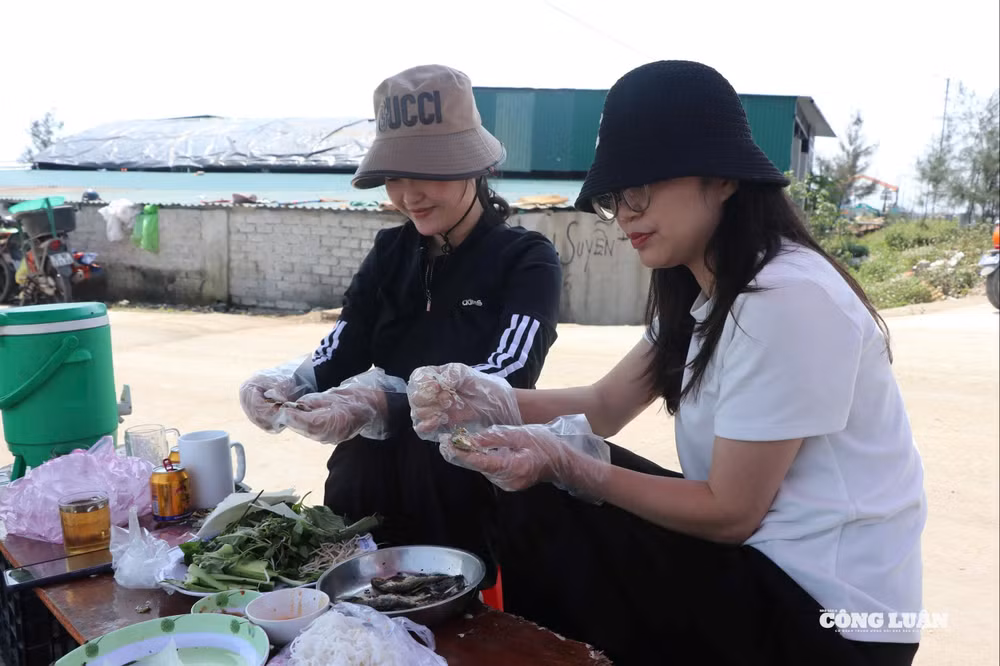 Các du khách thích thú khi thưởng thức cá trích nướng.