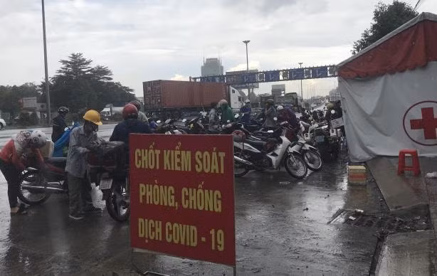 Người thực hiện khai báo y tế tại chốt kiểm soát y tế dưới chân cầu Đồng Nai.