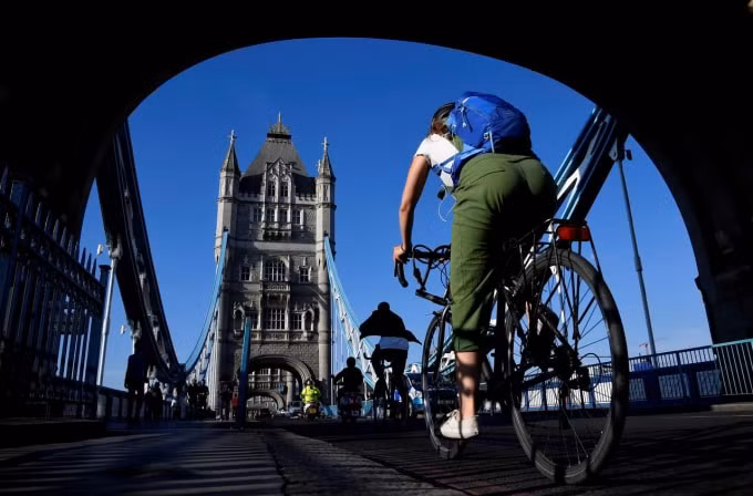 Người dân đạp xe qua cầu London. Ảnh: REuters