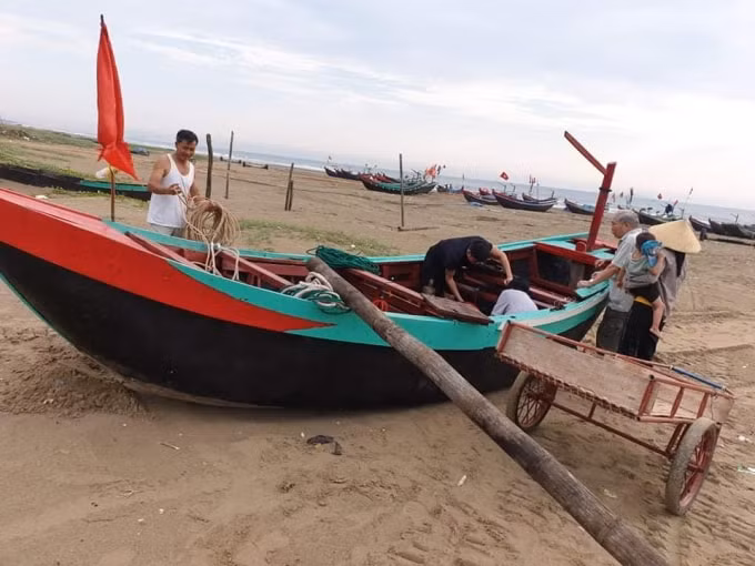 Một chiếc thuyền của ngư dân bị chìm tối qua đang được tu sửa lại