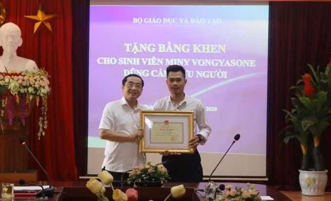 Vongyasone Miny (bên phải) nhận bằng khen của Bộ trưởng Bộ GD-ĐT từ lãnh đạo trường ĐH Hà Tĩnh. Ảnh: MT