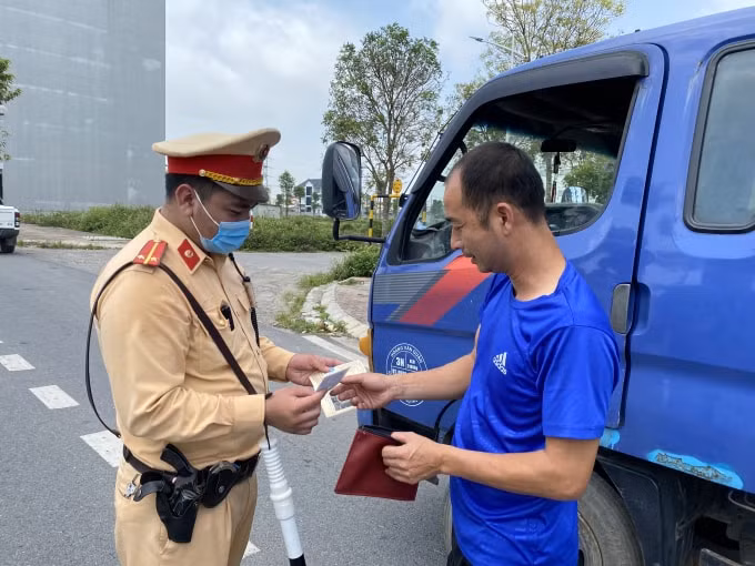 Lái xe chấp hành nghiêm chỉnh việc kiểm tra giấy tờ. Ảnh: Dương Lâm