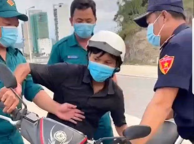 Anh Trần Văn Em ra ngoài mua bánh mỳ và bị tổ công tác giữ xe. Ảnh cắt từ clip