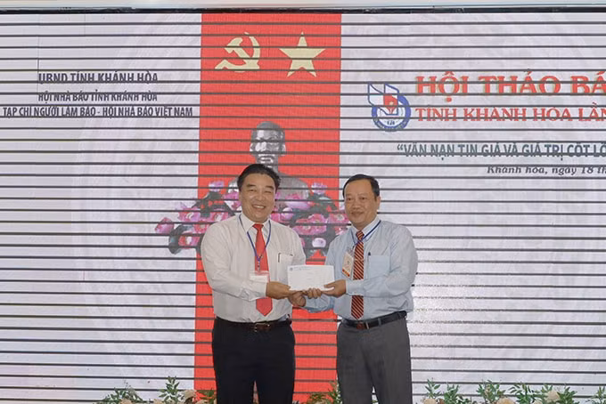 Ông Đoàn Minh Long - Chủ tịch Hội Nhà báo tỉnh Khánh Hòa (bên trái) trao số tiền các đại biểu quyên góp ủng hộ đồng bào miền Trung tới đại diện Ủy ban MTTQ Việt Nam tỉnh Khánh Hòa. Ảnh: N.T