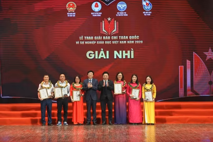 Phó Chủ tịch Thường trực Hội Nhà báo Việt Nam và Phó Tổng biên tập báo Nhân dân Quế Đình Nguyên trao giải Nhì cho các tác giả. Ảnh: Sơn Hải