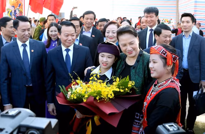 Các cháu thiếu niên tặng hoa chúc mừng Chủ tịch Quốc hội Nguyễn Thị Kim Ngân dự Lễ công bố đạt chuẩn nông thôn mới và Ngày hội Đại đoàn kết tại xã Quang Minh.