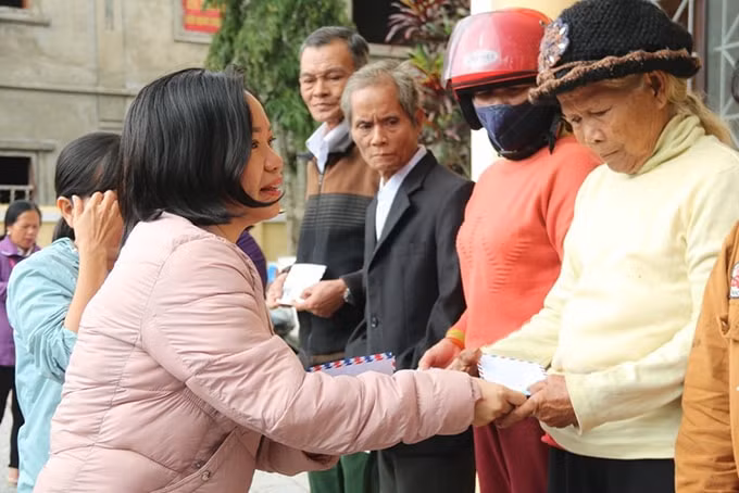 Bà Thái Thị Lệ Hằng, Phó Tổng Biên tập Báo Khánh Hòa tặng quà cho người dân A Lưới. Ảnh: Thiện Tâm