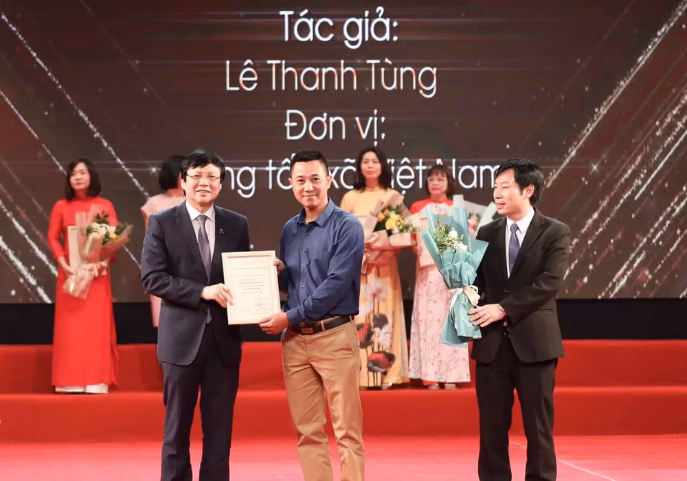 Nhà báo Hồ Quang Lợi - Phó Chủ tịch Thường trực Hội Nhà báo Việt Nam trao giải cho tác giả Lê Thanh Tùng - Thông tấn xã Việt Nam đoạt giải Ba.
