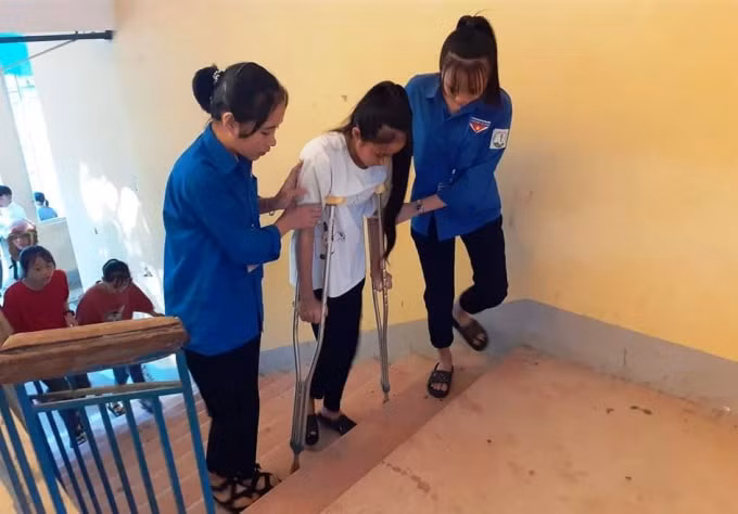 Thanh niên tình nguyện hỗ trợ thí sinh ở Kỳ Anh bước vào phòng thi