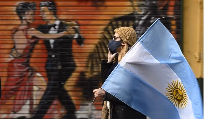Một người phụ nữ cầm một lá cờ Argentina trong một cuộc biểu tình chống lại biện pháp phong tỏa ở Buenos Aires. Ảnh: AFP