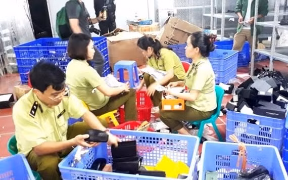 Lực lượng chức năng kiểm tra và thu giữ các mặt hàng nhập lậu, tại kho hàng 145, đường Hoàng Diệu, phường Lào Cai, thành phố Lào Cai. Ảnh: TL.