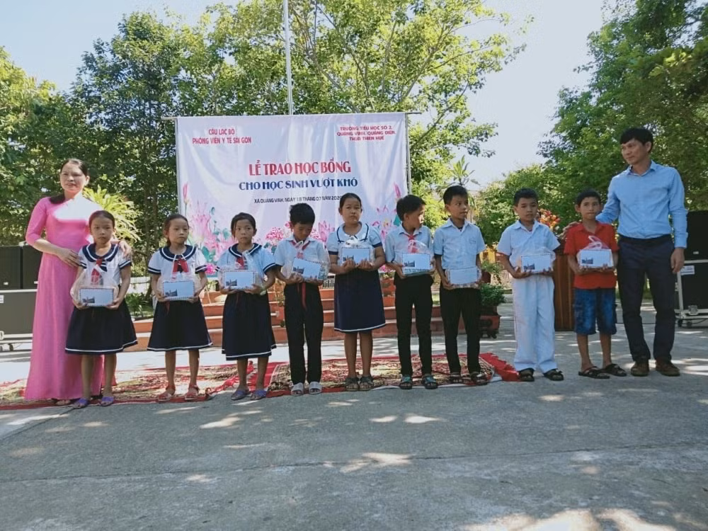 Đại diện CLB Phóng viên y tế Sài Gòn - Nhà báo Trần Ngọc Lâm trao quà cho các em học sinh nghèo vượt khó ở huyện Quảng Điền, tỉnh Thừa Thiên Huế.