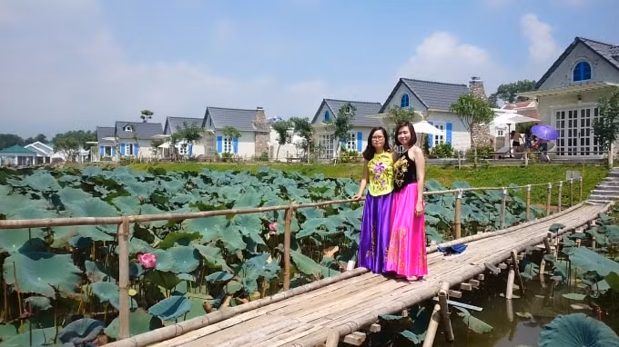 Chụp ảnh lưu niệm với yếm đào tại đầm sen Bạch Thủy.
