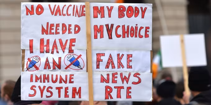 Một biểu ngữ phản đối tiêm vắc xin đồng thời gọi hãng tin RTE là fake news. Ảnh: GI