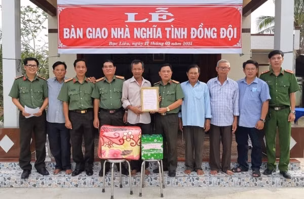 Lực lượng Công an tỉnh Bạc Liêu bàn giao nhà nghĩa tình đồng đội cho gia đình ông Lê Hoàng Ai. (Ảnh: Văn Sum)