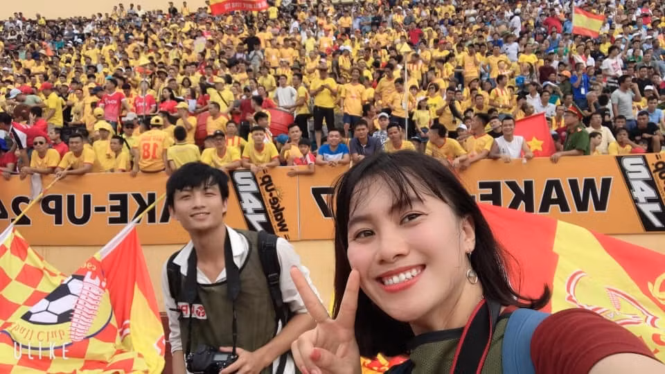 Phóng viên Cao Oanh chụp ảnh cùng cổ động viên CLB SLNA tại giải bóng đá Vô địch Quốc gia V.league.