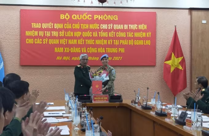 Thượng tướng Nguyễn Chí Vịnh, Thứ trưởng Quốc phòng, trao quyết định của Chủ tịch nước cho trung tá Trần Đức Hưởng. (Ảnh: DN)