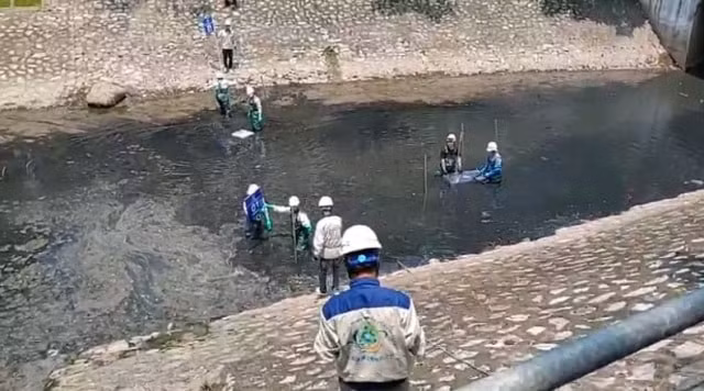 Các công nhân đưa đường dẫn xuống làm sạch sông Tô Lịch. Ảnh: T.Q