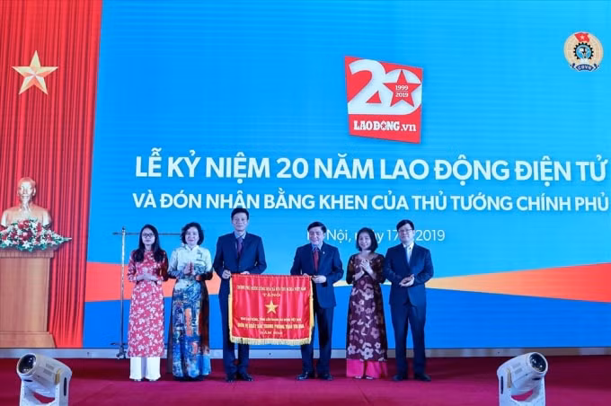 Chủ tịch Tổng LĐLĐVN Bùi Văn Cường trao cờ thi đua của Thủ tướng Chính phủ cho tập thể Báo Lao Động. Ảnh: Sơn Tùng
