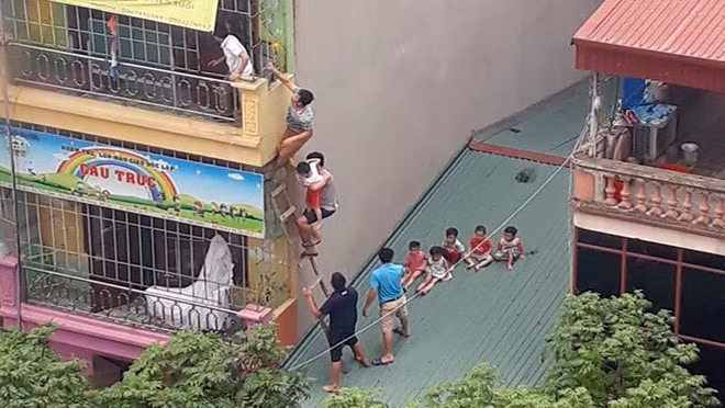 Người dân bắc thang gỗ cứu trẻ thoát ra ngoài. Ảnh: Thanh niên