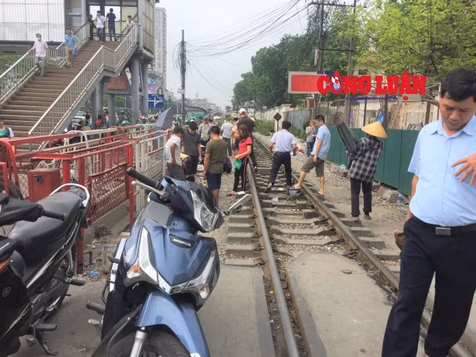Xe cộ được để tràn lan, người dân vô tư đi lại trên đường tàu