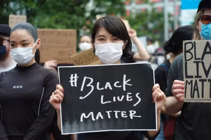 Một người phụ nữ cầm biểu ngữ Black Lives Matter hôm thứ 7 vừa qua. Ảnh: japantimes