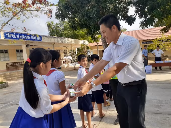 Các thầy cô giáo phát sữa cho các em học sinh nhân ngày đầu tiên bắt đầu uống sữa học đường
