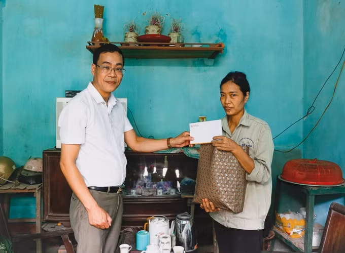 Chị Đỗ Thị Núi nhận quà hỗ trợ của đại diện lãnh đạo Tập đoàn T&T Group.