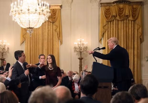 Nhân viên Nhà Trắng cố lấy lại micro trong khi phóng viên Jim Acosta tiếp tục nói.