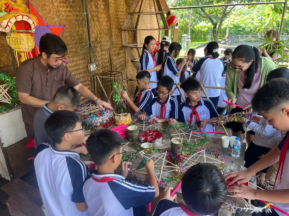Nghệ nhân ưu tú Nguyễn Tấn Phát trực tiếp hướng dẫn các em nhỏ trải nghiệm làm đèn ông sao. Ảnh: Tấn Phát 1789914581043-5600494491789780804-5600494491789780804-da2377a34fbaebc964d92d7fa4f27738.jpg