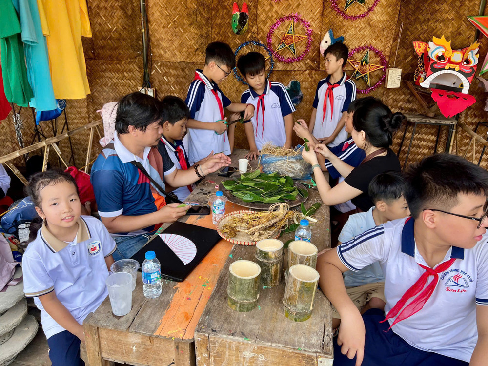 Các em nhỏ trải nghiệm làm trâu lá đa. Ảnh: Tấn Phát 1789914581014-5600494491789780804-5600494491789780804-53a4db40b124205ea7e6879ea52a4f76.jpg