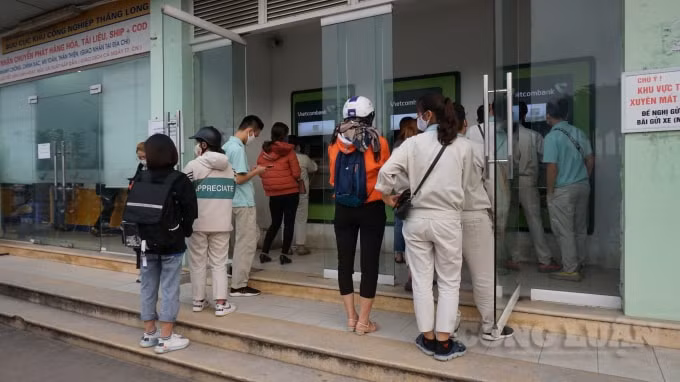 Chỉ khoảng hơn 5 mét vuông có tới hơn 10 người đứng xếp hàng chờ tới lượt mình rút tiền như thế này. Ảnh H.Long.