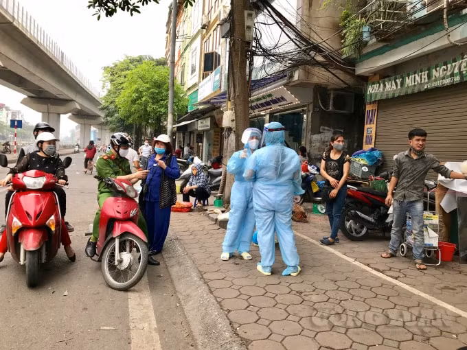Nhân viên y tế, công an vận động các tiểu thương, người lao động tự do tại khu vực chợ Ngã Tư Sở đi lấy mẫu xét nghiệm