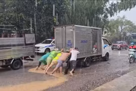 Cảnh sát giao thông dầm mưa, đẩy xe giúp người dân qua điểm ngập úng