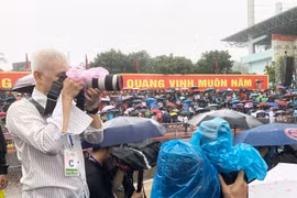 Hình ảnh phóng viên tác nghiệp dưới mưa tại lễ Kỷ niệm 70 năm Chiến thắng Điện Biên Phủ