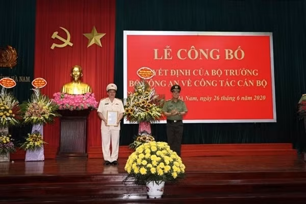 Thứ trưởng Lê Tấn Tới trao Quyết định và tặng hoa chúc mừng Đại tá Nguyễn Quốc Hùng. Ảnh: CAND