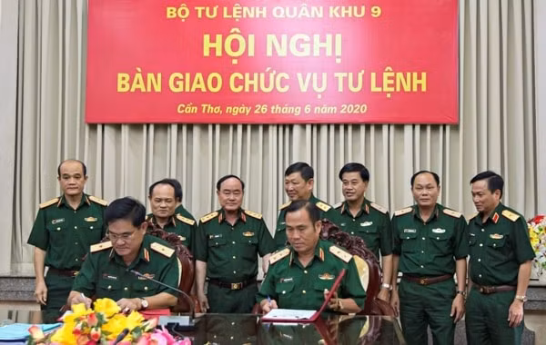 Trung tướng Nguyễn Hoàng Thủy (ngồi, bìa phải) và thiếu tướng Nguyễn Xuân Dắt ký biên bản bàn giao chức vụ ngày 26/6