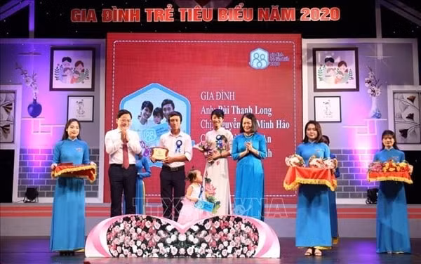 Bí thư Thường trực Trung ương Đoàn, Chủ tịch Trung ương Hội Liên hiệp Thanh niên Việt Nam Nguyễn Anh Tuấn tuyên dương các gia đình trẻ tiêu biểu. Ảnh: TTXVN