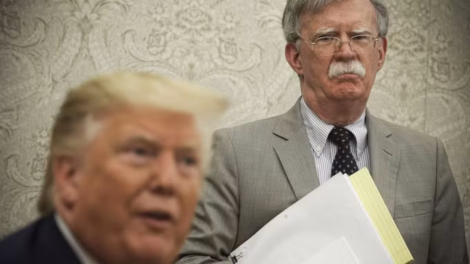 John Bolton nhìn Tổng thống Trump khi ông đang nói chuyện với các phóng viên trong cuộc gặp với Tổng thống Romania vào ngày 20/ 8 / 2019. Ảnh: Alex Wong / Getty Images