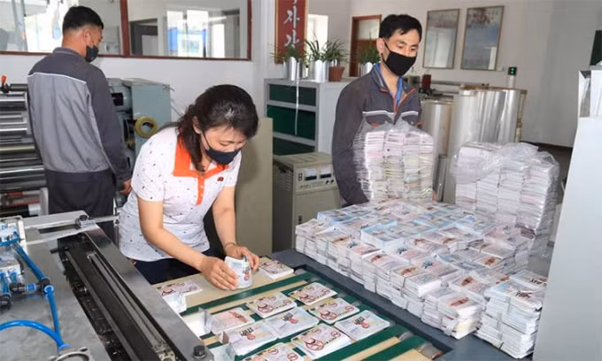 Công nhân Triều Tiên sắp xếp các tờ truyền đơn chuẩn bị gửi xuống miền Nam - Ảnh: KCNA