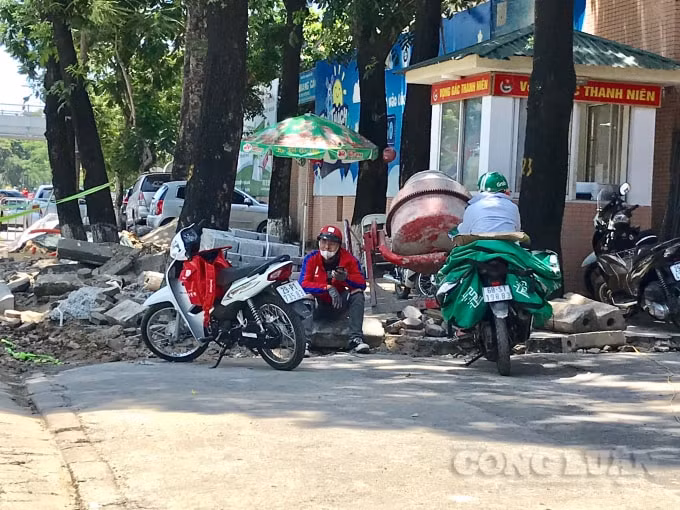 Nhân viên giao hàng tranh thủ tìm nơi có bóng mát để tránh cái nắng nóng gay gắt giữa trưa hè