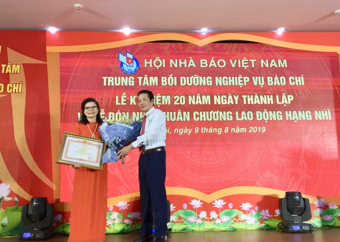 Đồng chí Hoàng Vĩnh Bảo, Thứ trưởng Bộ Thông tin và Truyền thông trao Bằng khen của Thủ tướng Chính Phủ cho bà Đinh Thị Thúy Hằng, Giám đốc Trung tâm Bồi dưỡng nghiệp vụ báo chí. Ảnh: Hoàng Huy