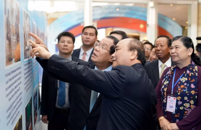 Thủ tướng Nguyễn Xuân Phúc và Thủ tướng Hun Sen xem một số hình ảnh trưng bày tại Hội nghị. Ảnh: VGP