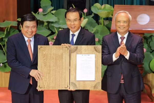 Phó Chủ tịch Quốc hội Uông Chu Lưu (phải) trao Nghị quyết cho lãnh đạo Thành uỷ, UBND TP Hồ Chí Minh. Ảnh: VNE