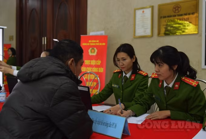 Cán bộ công an kiểm tra thông tin, giấy tờ của người dân.