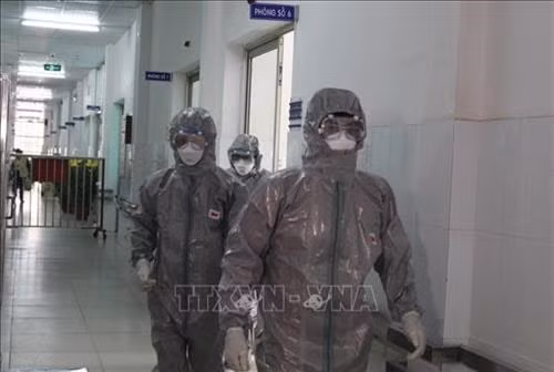 Theo hướng dẫn của Bộ Y tế: Trong trường hợp các tỉnh/thành phố có tổ chức thi cho học sinh có tiếp xúc gần với ca bệnh (F1) thì đảm bảo tất cả những người tham gia tổ chức thi phải mặc trang phục bảo hộ theo quy định và triển khai các biện pháp phòng tránh lây nhiễm chéo trong quá trình tổ chức thi (ảnh TTXVN).