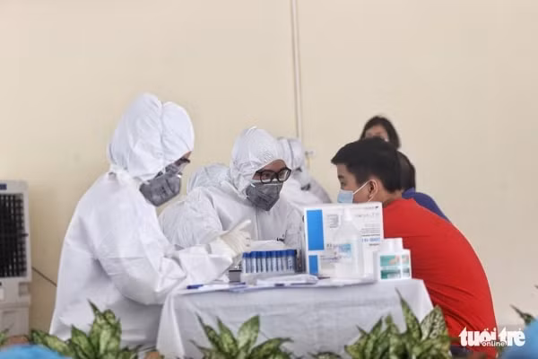 Các nhân viên y tế của TP Hà Nội thực hiện xét nghiệm nhanh cho người dân. Ảnh: TTO